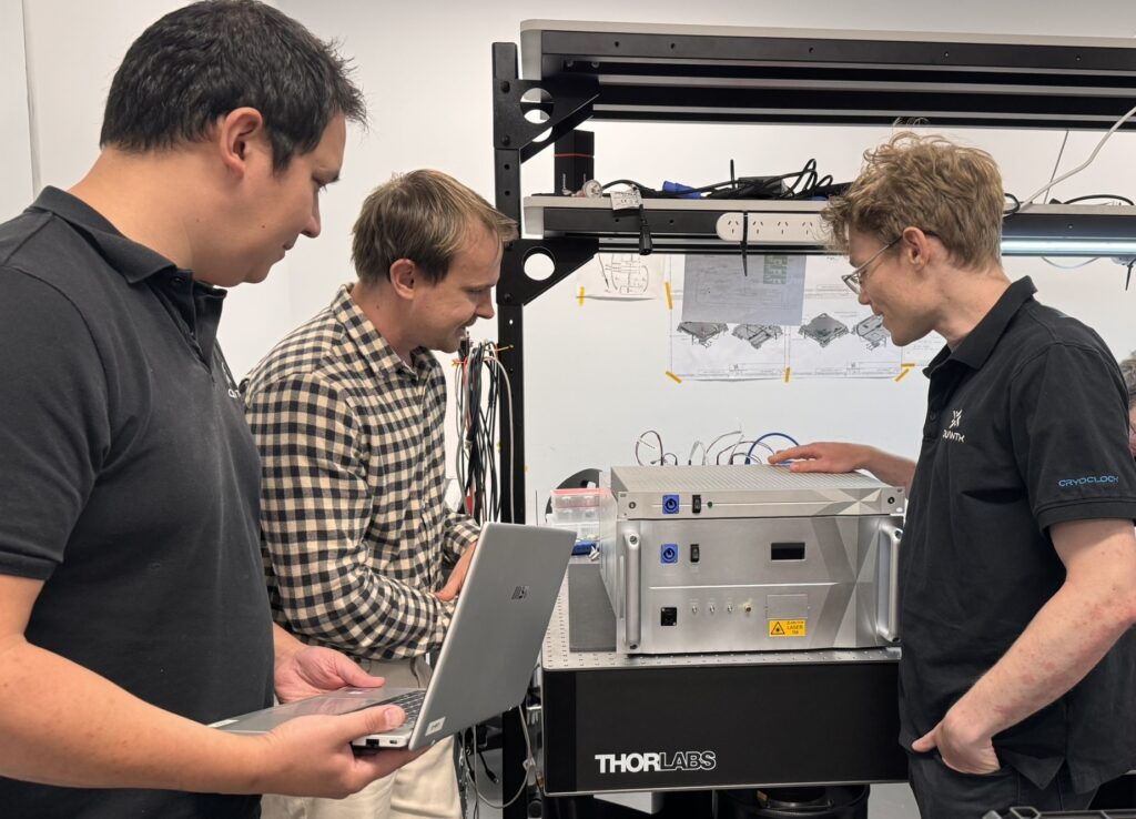 Dr Sebastian Ng, Head of Positioning, Navigation, and Timing at QuantX Labs; Adelaide University PhD researcher Lachlan Pointon; and Dr Reuben Harding, Senior Physicist at QuantX Labs, with QuantX Labs optical atomic clock.